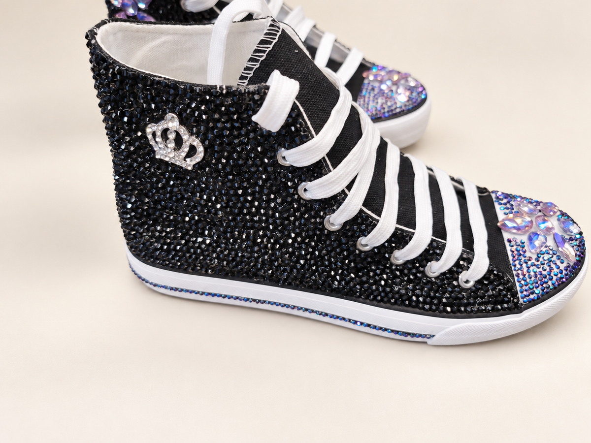 Black high top sneakers embellished with rhinestones, crown accents, and iridescent toe details